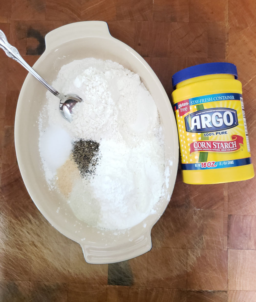 flour, cornstarch and spices in an oval ceramic baking dish to coat chicken.