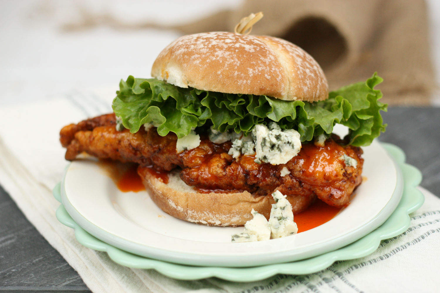 honey buffalo fried chicken on a roll with chunks of blue cheese.