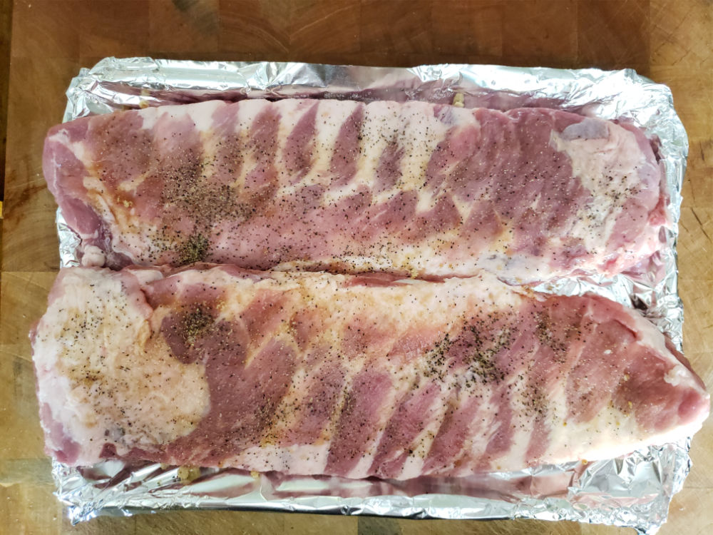 spare ribs on sheet pan seasoned with brown sugar, salt, and pepper
