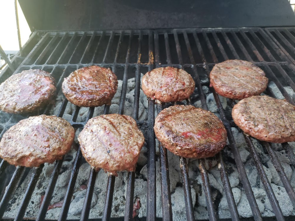burgers cooking on a charcoal grill