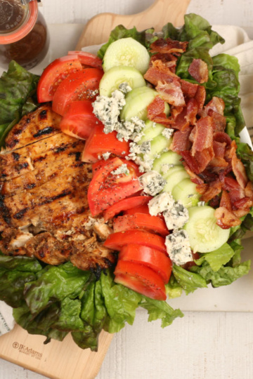 Garden salad with grilled chicken, tomatoes, blue cheese, cucumbers, and bacon