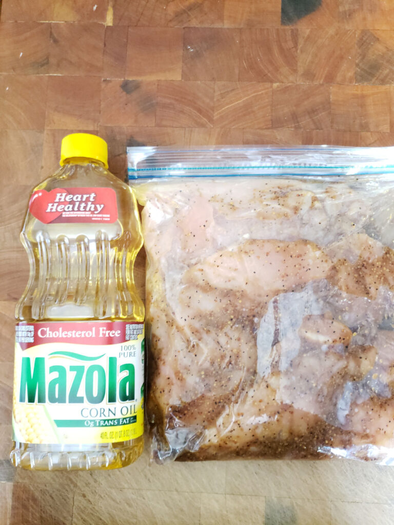 chicken breasts in a large ziploc bag marinating on butcher block