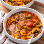 Soup with sausage, veggies and broth in bowl.