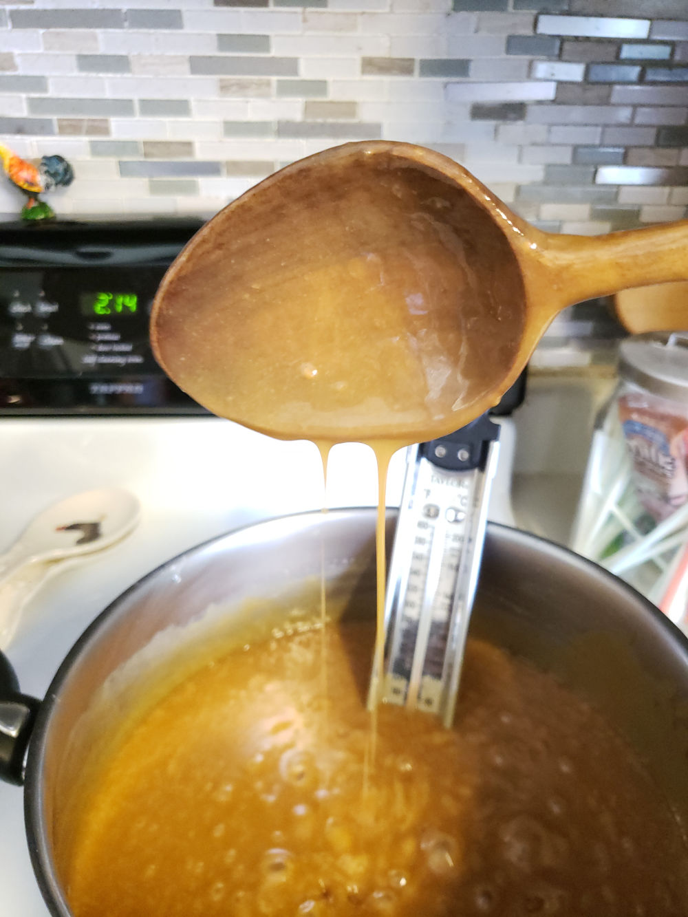 homemade caramel in pot with wooden spoon.