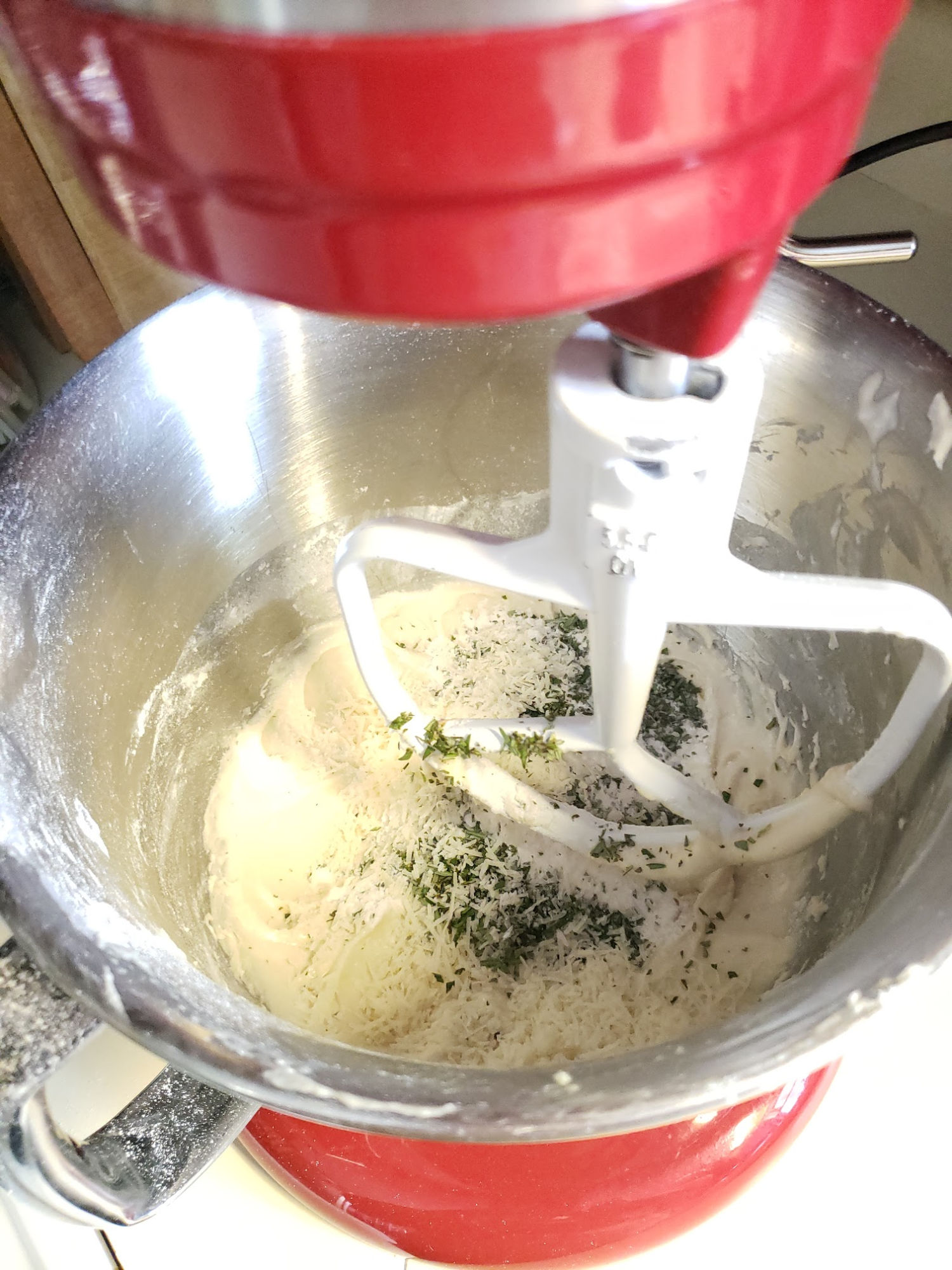 Red kitchenaid mixer with yeast dinner rolls dough in bowl