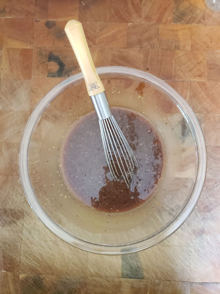 homemade balsamic dressing in a bowl with whisk