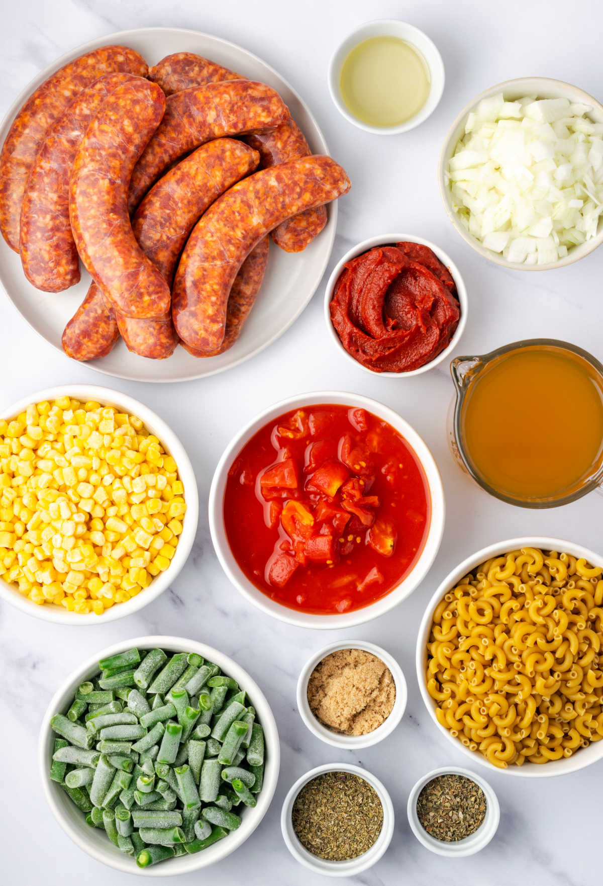 Ingredients in small white bowls for sausage soup.