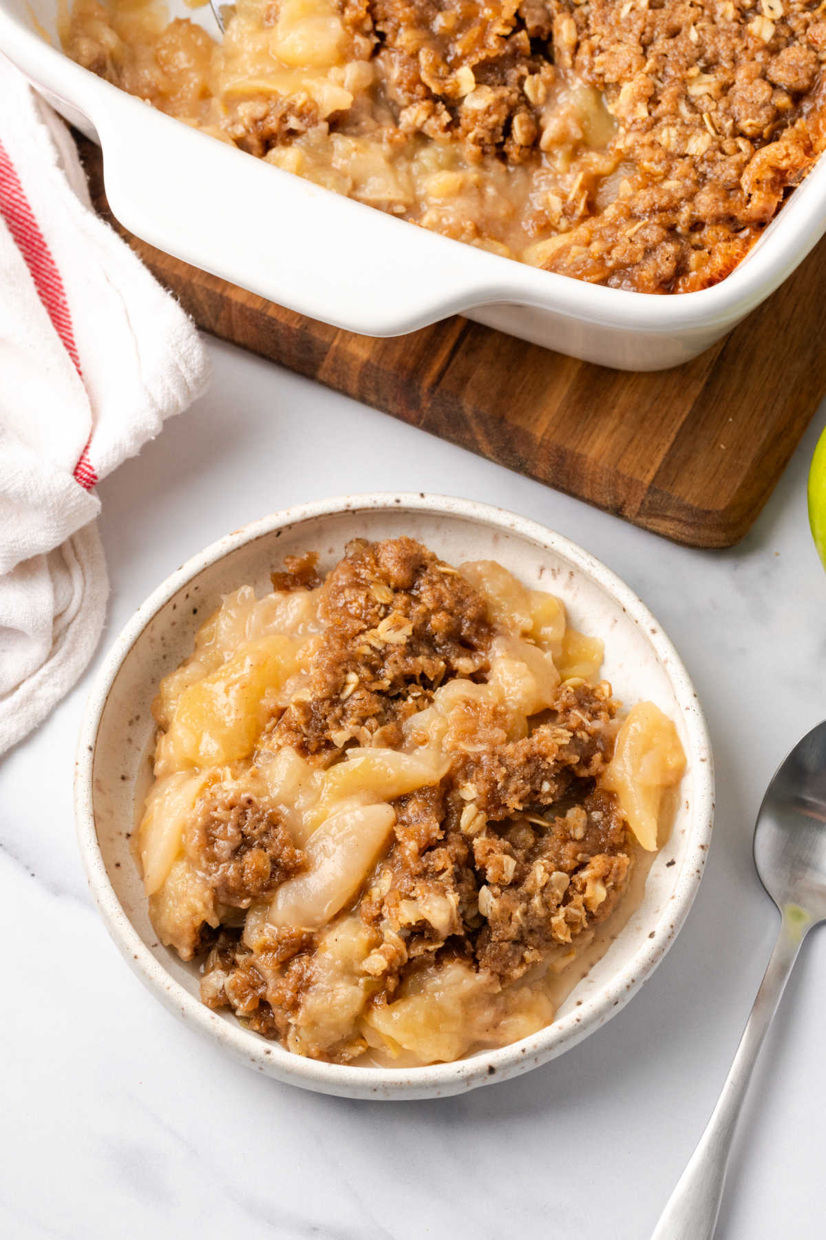 Small white bowl with apples and crumb topping.