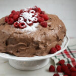 chocolate frosting on chocolate cake with fresh raspberries on top