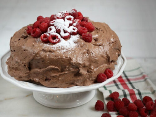 chocolate frosting on chocolate cake with fresh raspberries on top