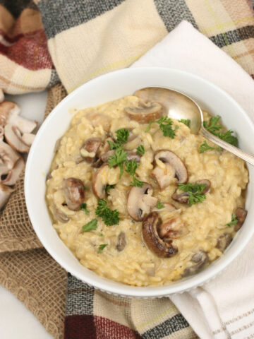 Mushroom risotto in a white bowl with a spoon