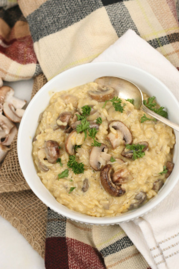 Mushroom risotto in a white bowl with a spoon