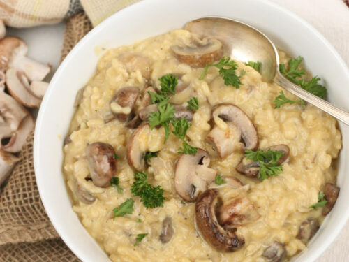 Mushroom risotto in a white bowl with a spoon