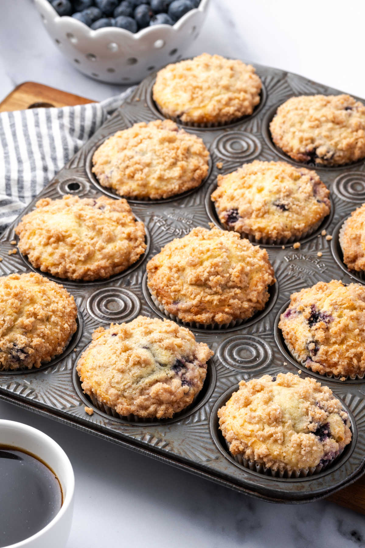 Muffins in vintage muffin tin, fresh blueberries in background.