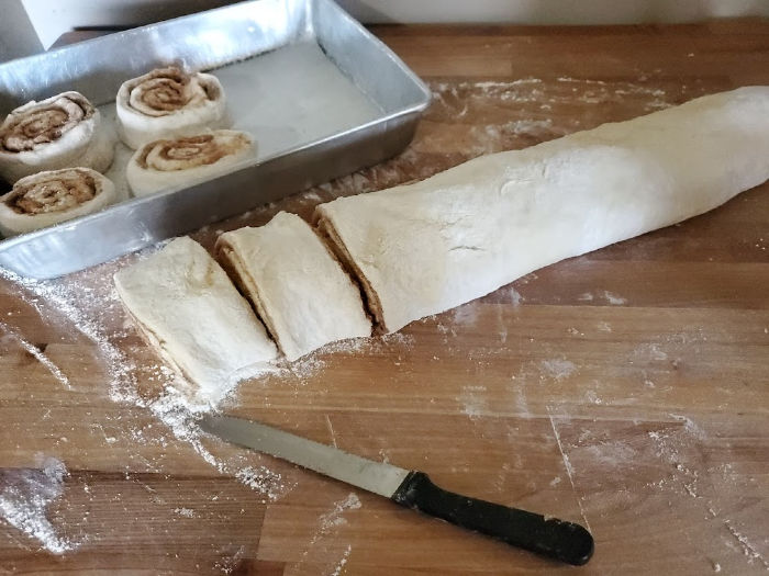 cutting cinnamon rolls on butcher block