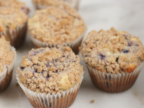Blueberry muffins with crumb topping on white marble