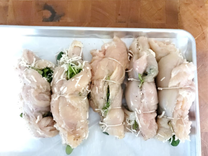 spinach and cheese stuffed chicken breasts on half sheet pan