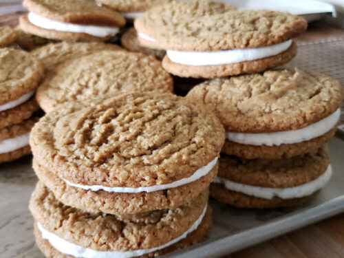 oatmeal cream sandwiches stacked on each other on sheet pan