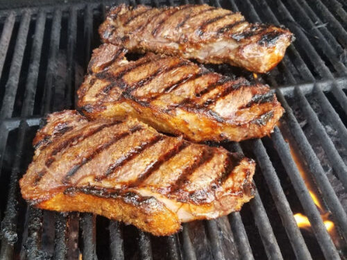 grilling steaks on charcoal grill
