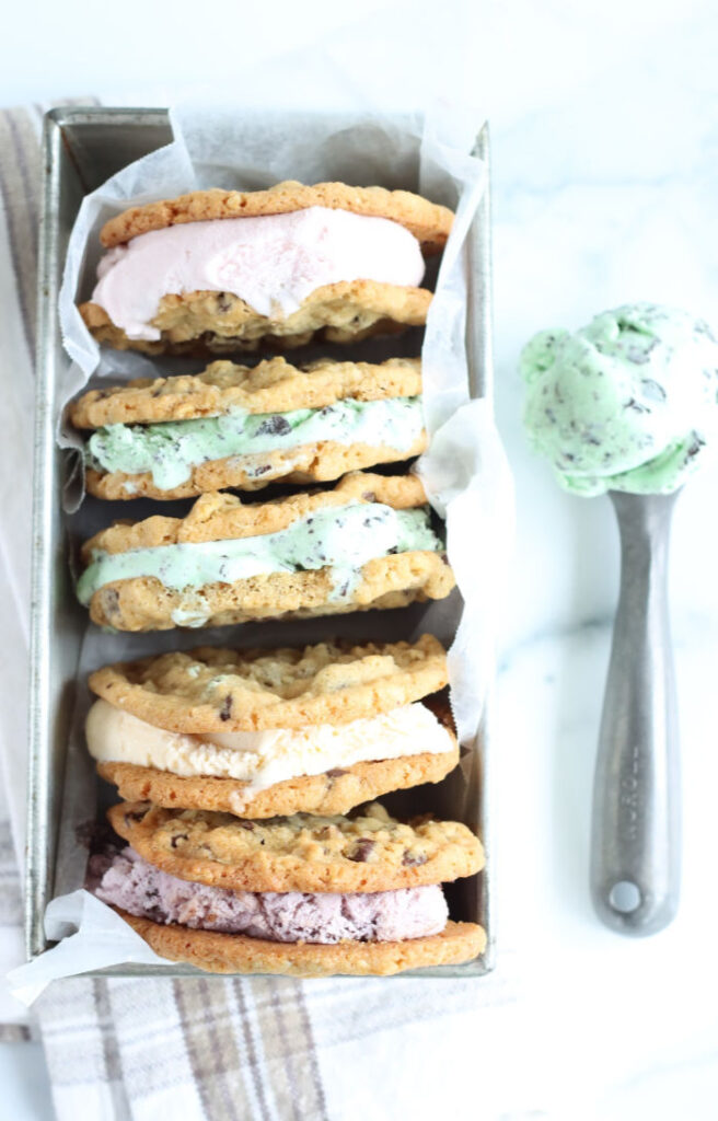 thin chocolate chip cookie ice cream sandwiches with different kids of ice cream stacked against each other in a metal loaf pan
