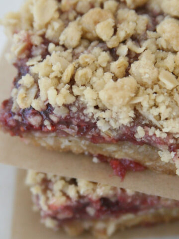 Raspberry bars in squares stacked on top of each other.
