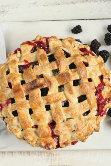 blackberry pie with lattice crust, fresh blackberries around it.