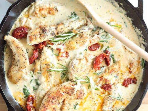 chicken with cream sauce, sun-dried tomatoes, spinach, in cast iron skillet, spoon in pan