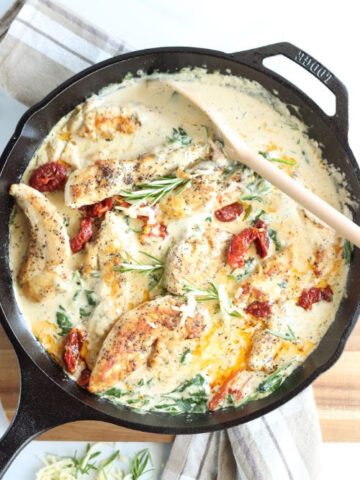 Chicken in cast iron skillet with sun dried tomatoes, spinach, and fresh rosemary