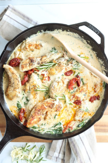 Chicken in cast iron skillet with sun dried tomatoes, spinach, and fresh rosemary