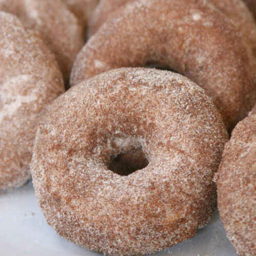 Apple donuts coated in cinnamon sugar.