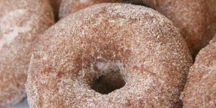 Apple donuts coated in cinnamon sugar.