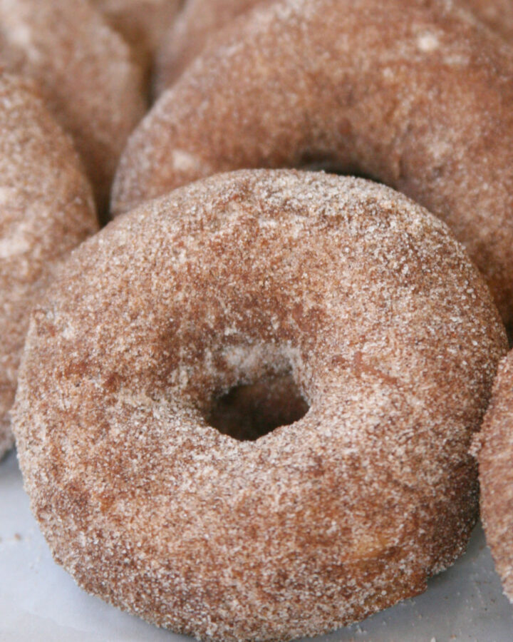 Apple donuts coated in cinnamon sugar.