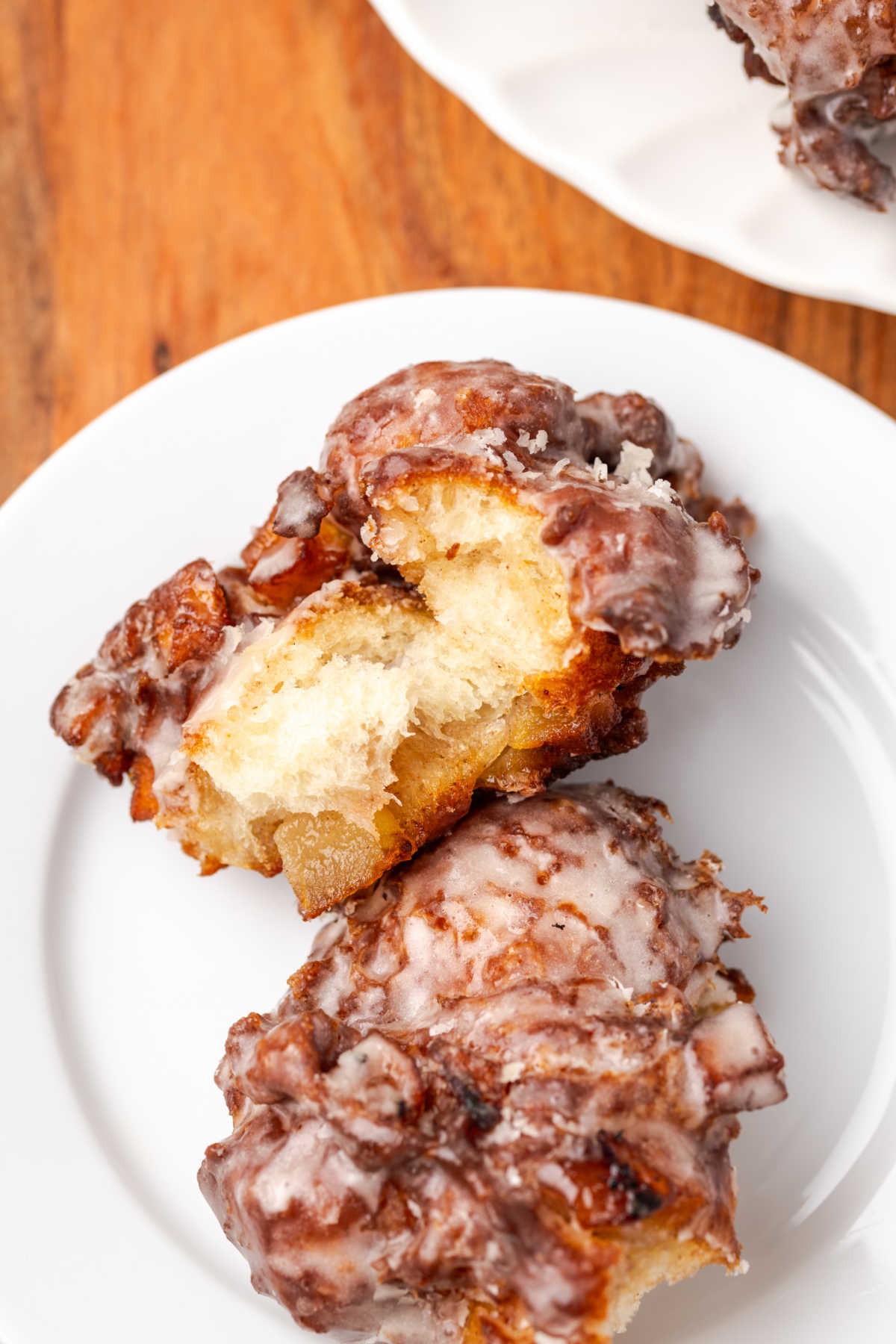 Apple fritters on small white plate.