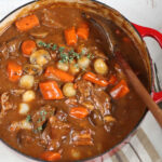 Close up of Beef Bourguignon in red Dutch oven.