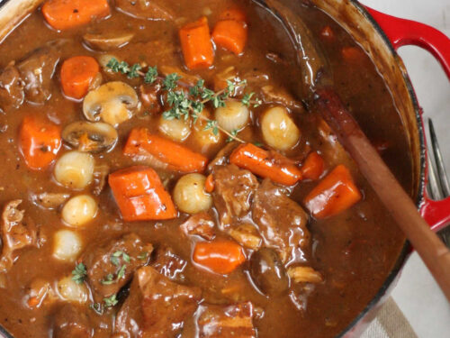 Close up of Beef Bourguignon in red Dutch oven.