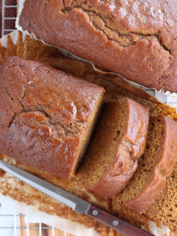 Two loaves of pumpkin bread, one partially sliced.
