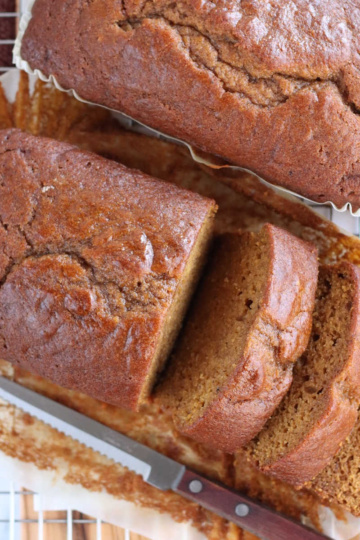 Two loaves of pumpkin bread, one partially sliced.