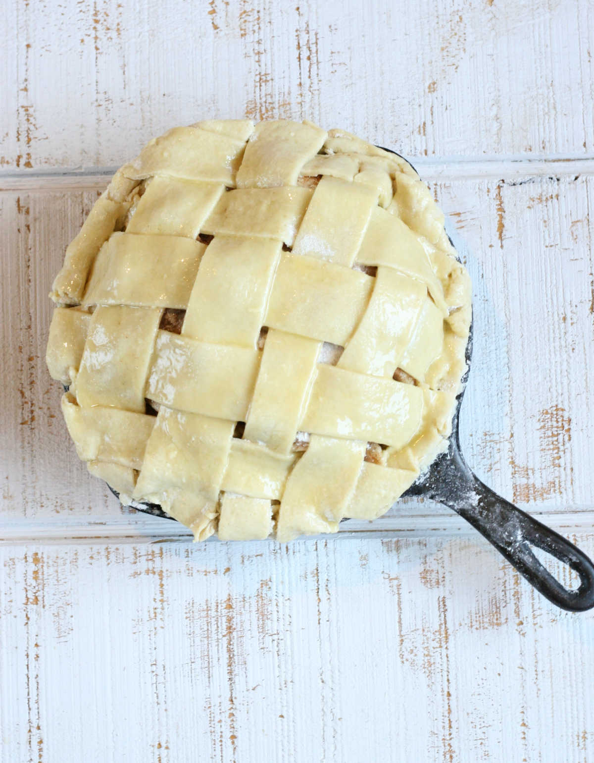 unbaked pie with lattice crust in a small cast iron skillet.