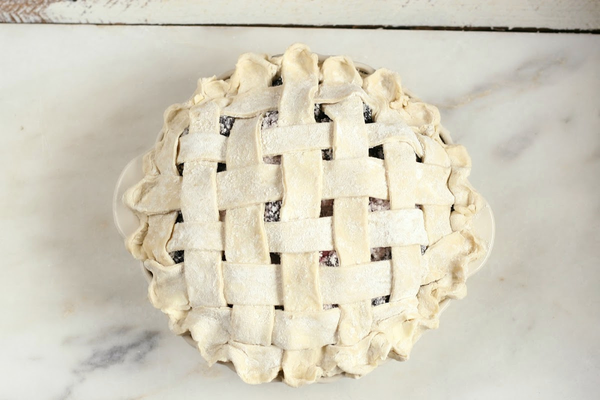 weaved lattice pie crust on berry pie before baking.