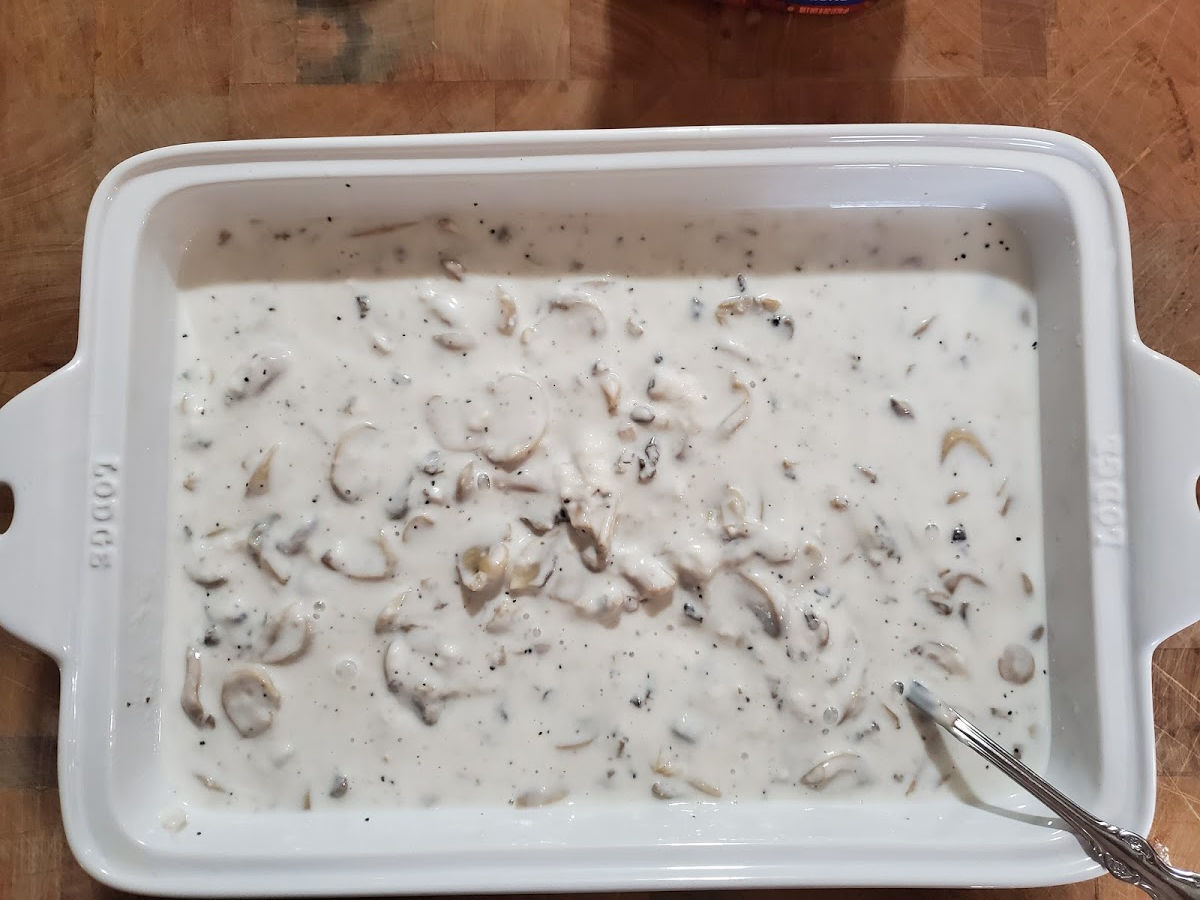 white rectangle ceramic baking dish with milk and mushrooms.