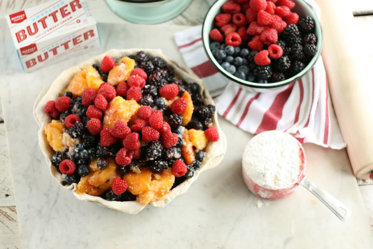 making berry pie, berries in mint green enamelware bowl to side.