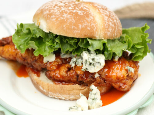 Fried buffalo chicken sandwich with green leaf lettuce and chunks of blue cheese.