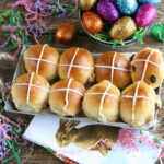 Hot cross buns with cranberries in metal serving tray, sparkled eggs.
