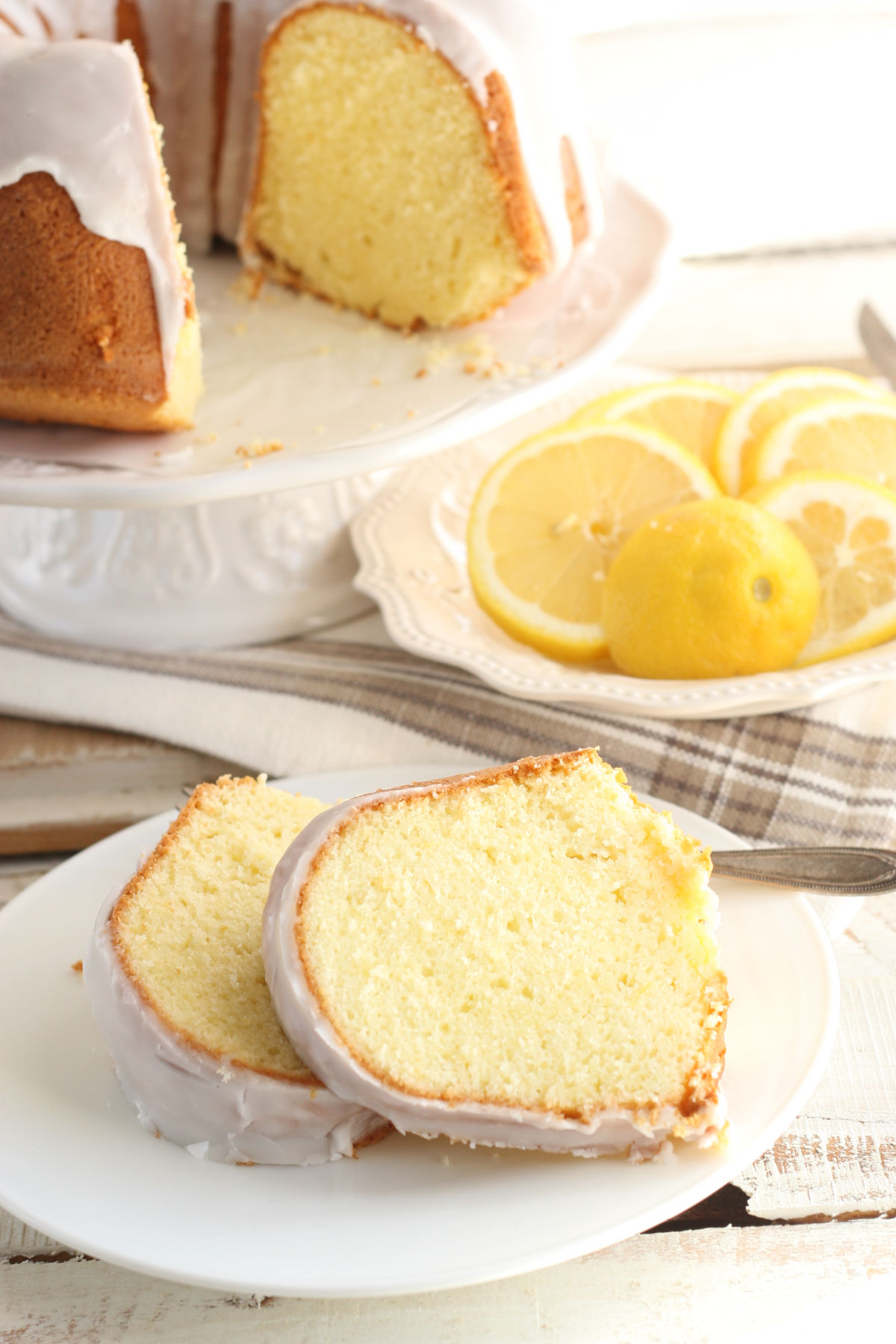 Slices of lemon Bundt cake with icing on small white plate.