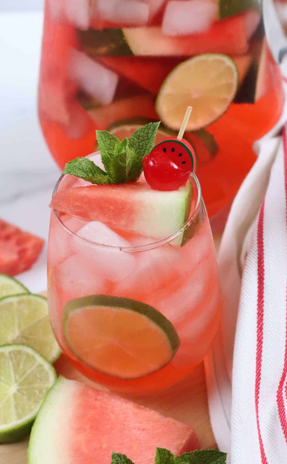 Stemless wine glass with watermelon sangria, watermelon wedges around.