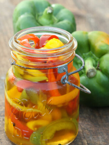 Vintage Mason jars filled with multi color pickled sweet peppers.