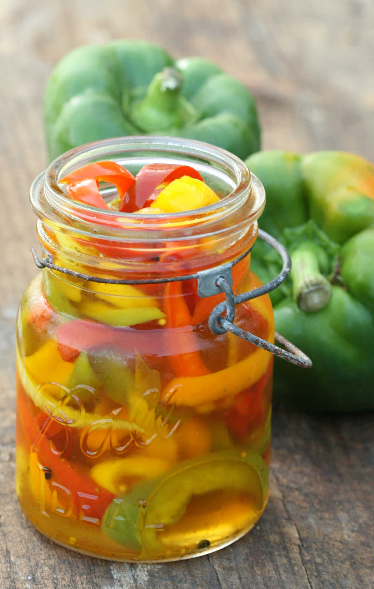 Vintage Mason jar of pickling peppers on reclaimed wood board.