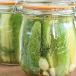Jars of pickle spears on wooden cutting boards.