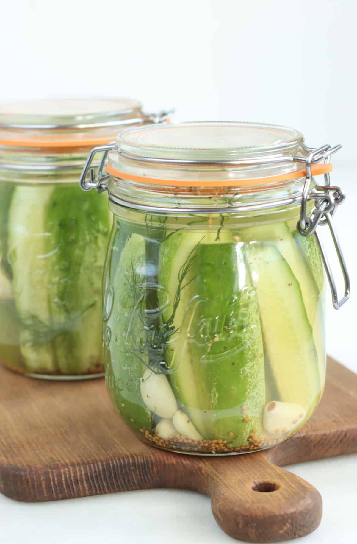 Glass jars with clasps and rubber seals with dill spears.