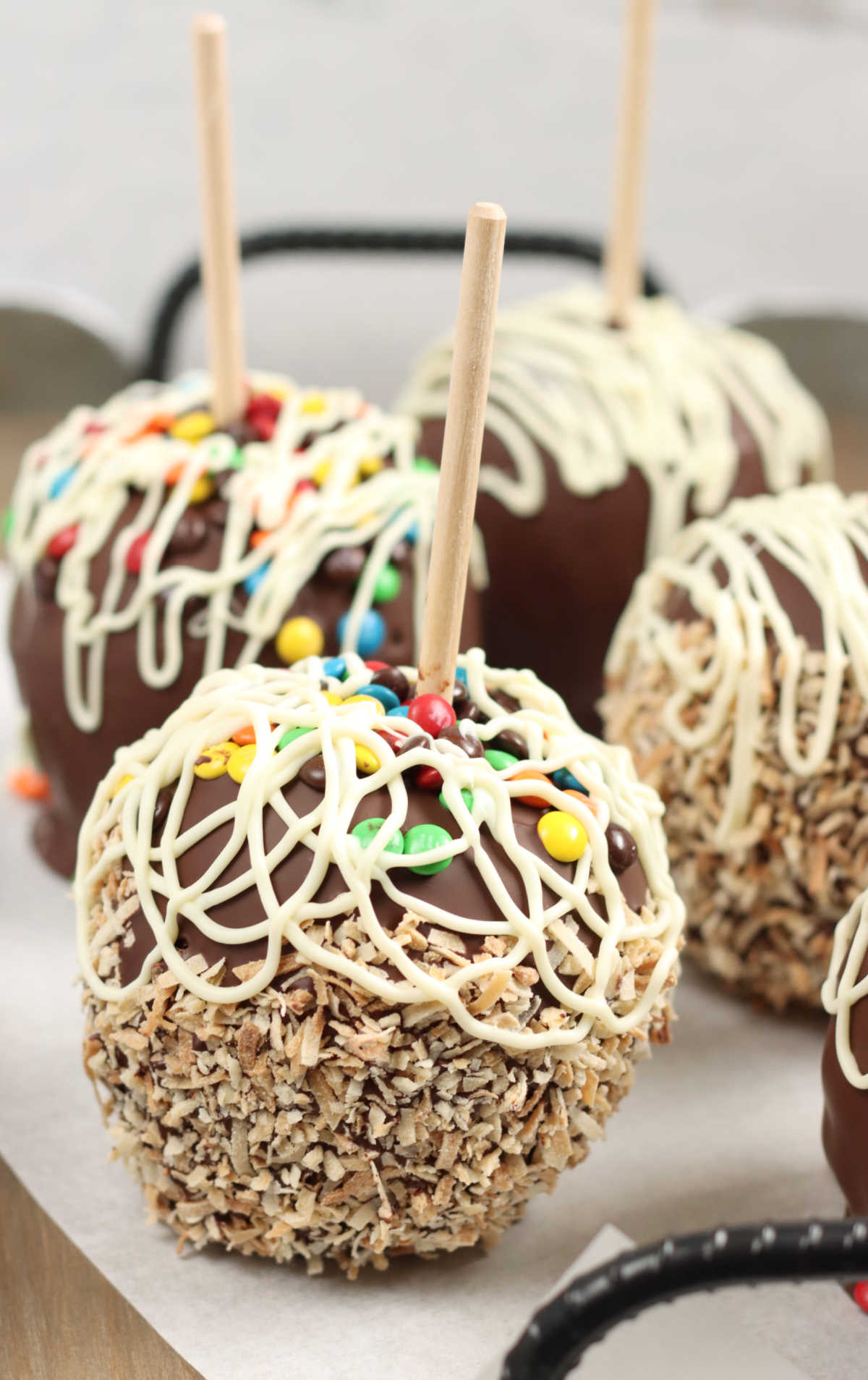 Caramel and chocolate dipped apples with toasted coconut on serving tray.